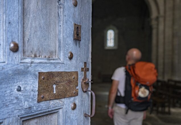 Un randonner sur le Chemin de Compostelle entre dans une église